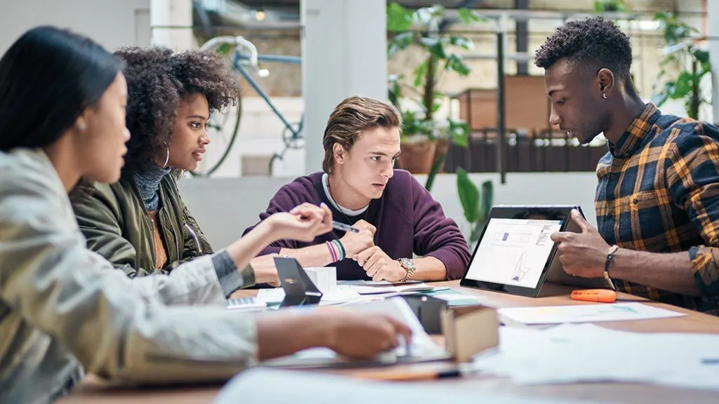 Grupo de personas trabajando en equipo con programas de Microsoft.